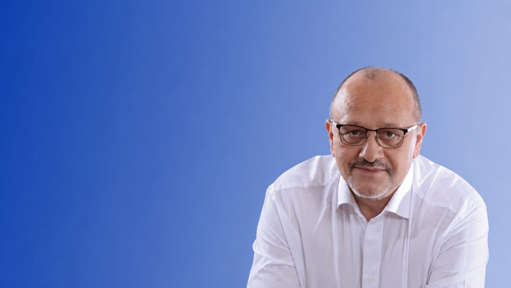 Bogdan Cristian Nica, în cămașă albă, pe fundal albastru